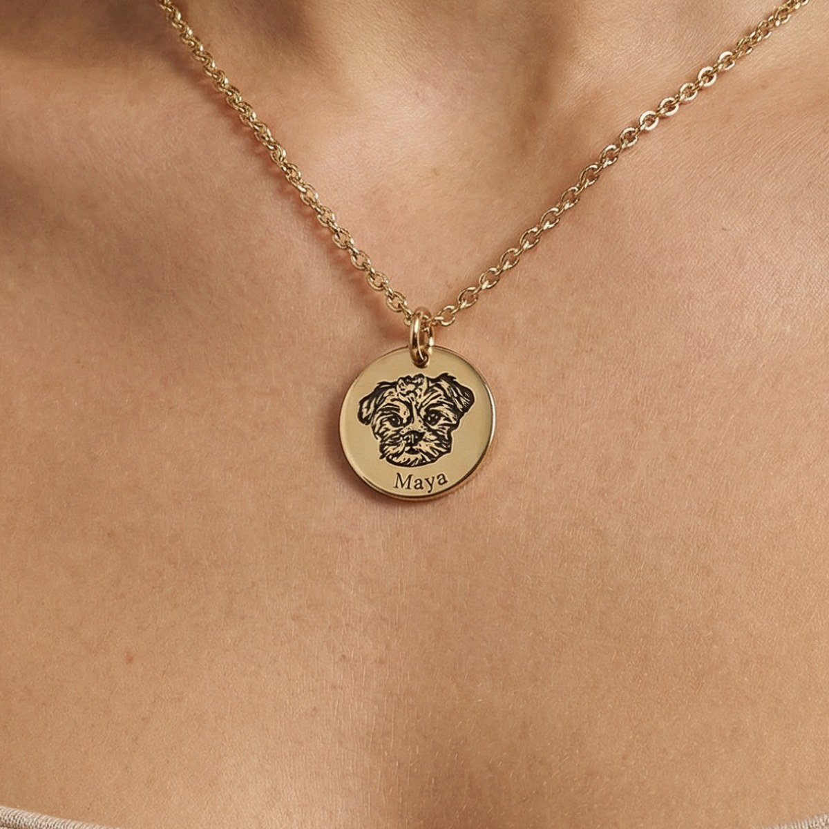 Collar de acero dorado puesto, con la carita de una mascota grabada